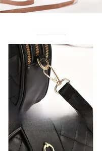 Detail einer schwarzen Stepptasche mit vergoldeten Beschlägen und Metallreißverschlüssen
