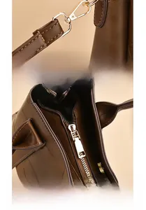 Close-up of polished gold hardware and multilayer plated metal buckle on brown leather bag