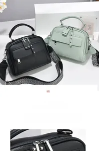 Detail of leather handbags with rivet pullers and geometric pattern wide shoulder straps