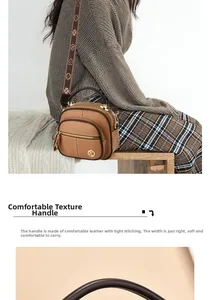 Detail of lychee pattern brown crossbody bag with wide floral strap and gold metal logo