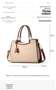 Detail view of cream handbag with brown crocodile texture straps and golden hardware