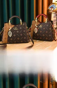 Detail of elegant tote bags with vintage floral patterns and metal pearl leaf pendant