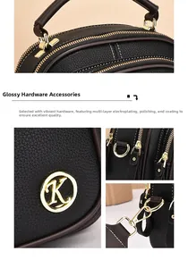 Detail of black lychee leather handbag with gold zippers and metal K logo hardware