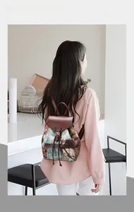 Mini multi-functional backpack with denim print and brown leather flap worn by a model