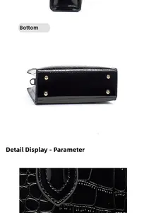 Detail view of the croc-embossed leather texture and gold protective studs on the handbag bottom