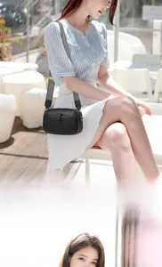 Detail of black pebbled leather mini crossbody bag with chic chevron woven shoulder strap