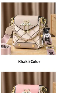 Detail of crossbody bag with golden swan buckle, pearl pendant and wide fabric strap
