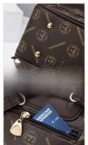 Detail of dark brown backpack showing gold metal feet and zippered interior compartment