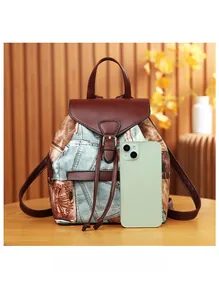 Size comparison of the vintage denim backpack with a smartphone showing its scale