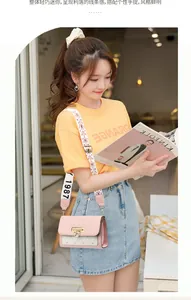 Close-up of pink mini flap crossbody bag with heart lock and decorative wide strap