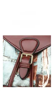 Detail of vintage leather backpack featuring artistic print and gold metal buckle closure