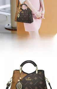 Detailed macro of the monogram print hand-held bag featuring a gold leaf charm and metal chain