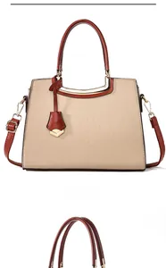 Detail of elegant beige handbag with crocodile pattern and brown handles on white background