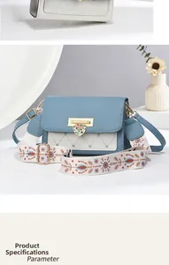 Close-up of heart-shaped metal lock and quilted heart pattern on blue crossbody bag
