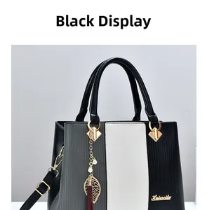 Detail der Handtasche im Color-Block-Design mit Blattanhänger, Perle und roter Quaste
