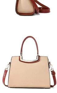 Detail of beige crocodile embossed tote bag with caramel straps and golden metal hardware