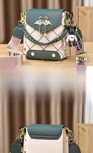 Detail of color-block crossbody phone bag with gold swan buckle and black bear charm