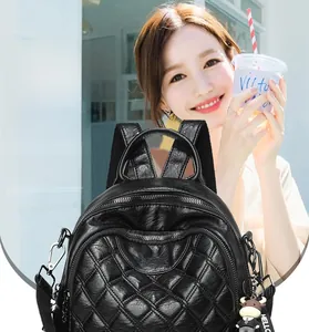 Detail of black quilted leather backpack with multi-layer zippers and cow doll charm