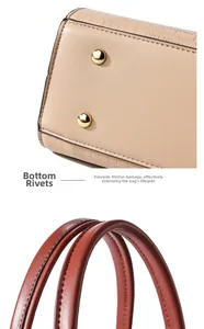 Detail of beige leather bag with gold rivets and reddish brown handles for durability