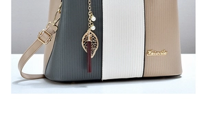 Detail der dreifarbigen Lederhandtasche mit vertikaler Textur und Perlenquasten-Anhänger