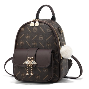 Brown monogram backpack with golden swan buckle, pearl tassels, and white plush charm