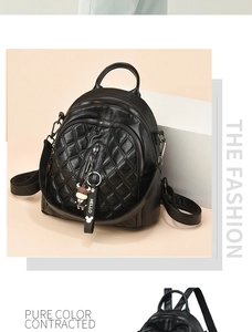 Detailed macro view of black quilted faux leather texture with a cute cow bag charm