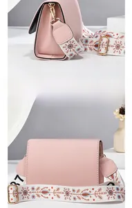 Detail view of pink crossbody bag with colorful floral jacquard strap and gold hardware