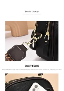 Detail view of black lychee leather mini crossbody bag with gold hardware and jacquard strap