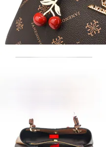 Detail of vintage tote bag interior featuring multiple compartments and cherry metal charm