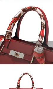 Detail of red leather handbag featuring litchi texture and printed silk scarf handle