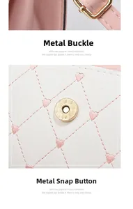 Detail of pink embroidered hearts on white quilted leather bag with gold hardware
