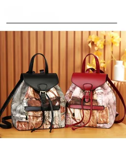 Detail of vintage canvas backpacks showing denim prints, leather flaps, and metal buckles