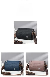 Three crocodile-embossed barrel bags in black, blue, and pink with clover metal logo