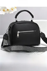 Rear view of black pebble leather handbag with zip pocket and chevron strap detail