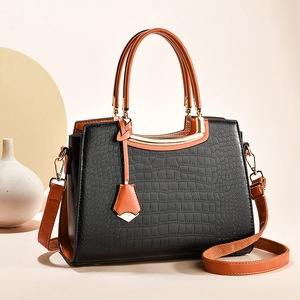 Elegant crocodile-patterned tote bag in black and brown with golden metal hardware