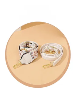 Detail showing detachable embroidered fabric wide strap and slim faux leather shoulder strap