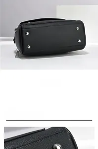 Detail showing the bottom of a black leather handbag with four silver metal protective feet