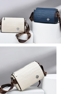 Detail of faux crocodile texture barrel bag with silver clover logo and jacquard strap