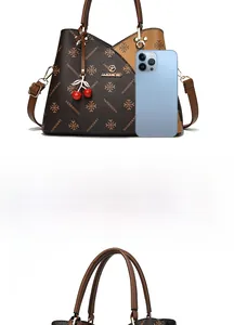 Close-up of vintage brown monogram tote with cherry pendant and golden metal hardware