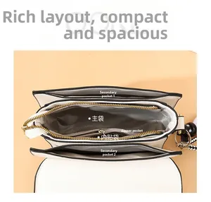 Top view of white crossbody bag with multiple inner pockets and gold zipper detail