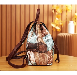 Detail view of a vintage bucket backpack with floral print and drawstring closure