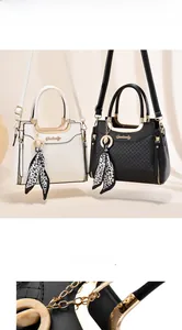 Detail of quilted leather handbag with gold round handle and leopard scarf accessory