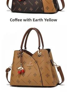 Detail of coffee and earth yellow tote with lychee grain leather and cherry pendant
