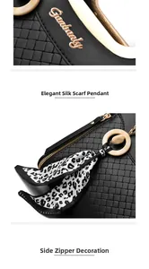 Detail of black woven handbag with gold logo, leopard print scarf and metal zipper