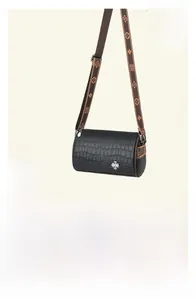 Detail of black crocodile texture barrel bag with wide jacquard shoulder strap and silver logo