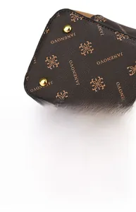 Detail of the dark brown leather handbag with gold rivets and magnetic buckle closure