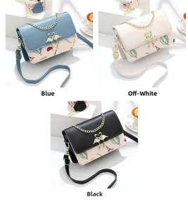Detalle del bolso bandolera con estampados de Torre Eiffel y hebilla de cisne dorada