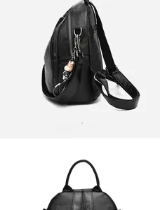 Detail view of black PU leather backpack featuring lychee texture and cartoon pendant