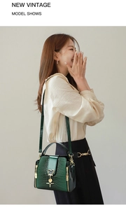 Detail shot of green crocodile pattern bucket bag with a golden Mickey-shaped pendant