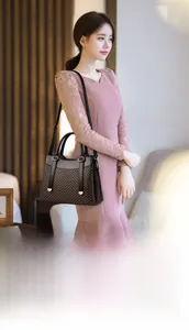 Detail of elegant two-tone brown tote bag with gold hardware worn by a model